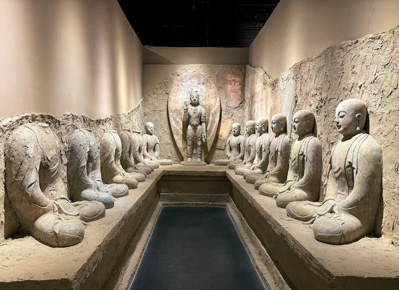 A row of seated Buddha statues in a cave. 1