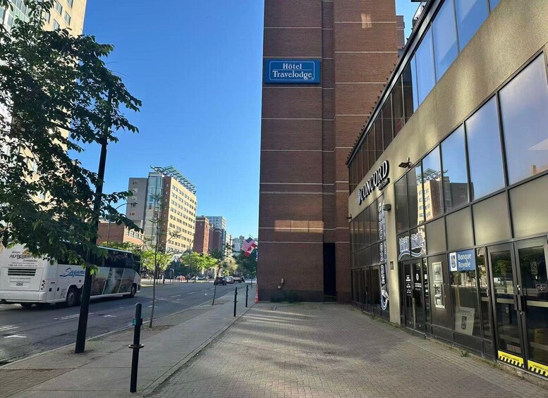 A city street with a hotel sign, a travel agency, and a bank. 2