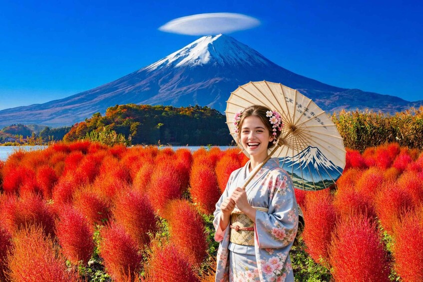 A person in traditional attire with a fan, standing in a field of red foliage with Mount Fuji in the background. 1