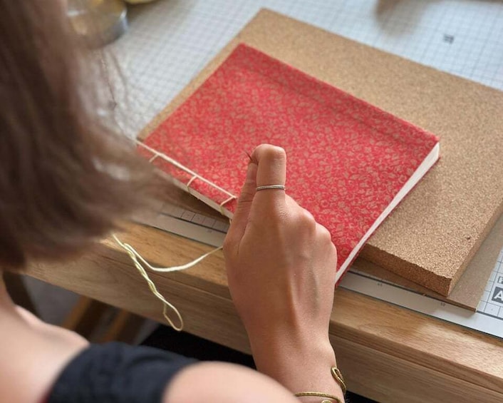 A person using a rotary tool on a red patterned material. 4
