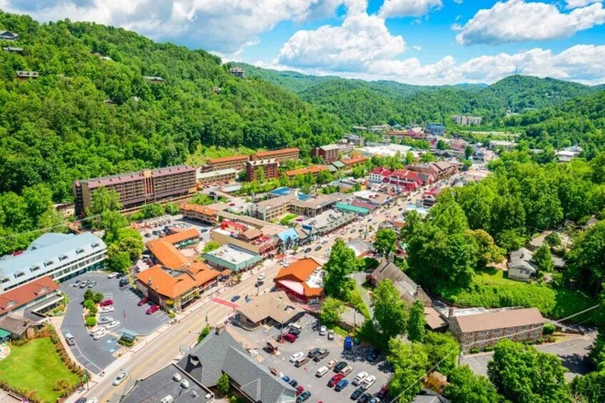 A town with a central road, buildings, and a hilly backdrop. 2