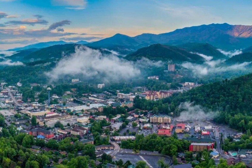 A town nestled in a valley with mountains in the background and steam rising from the ground. 5