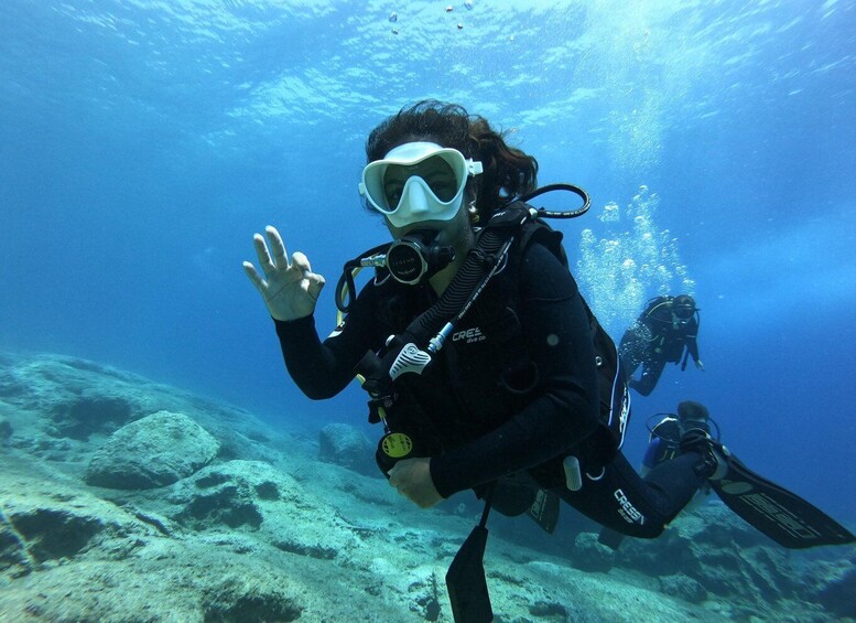 A scuba diver underwater with a reef in the background. 1