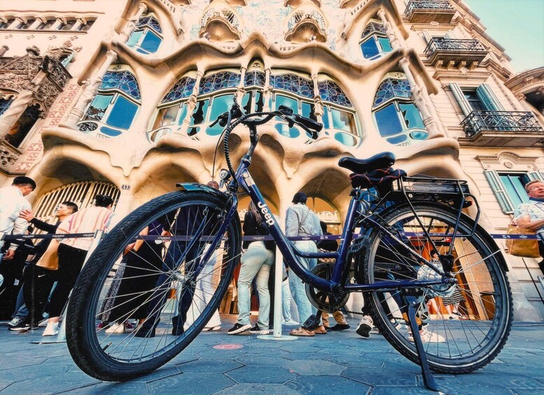 A bicycle parked in front of a building with ornate architecture and blue-tiled windows. 1