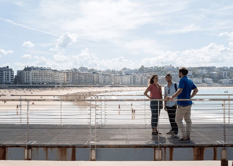 A coastal cityscape with a beach, buildings, and a pier. 3