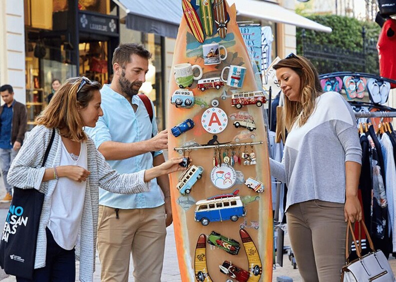 A colorful surfboard-shaped display with various toys and a large letter 'A' on it. 1