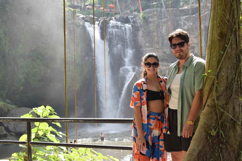 A waterfall with people in the background. 2