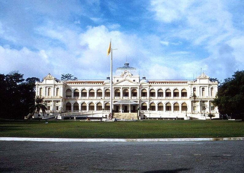 A large, ornate building with a central dome and multiple arches, surrounded by a well-maintained lawn. 5