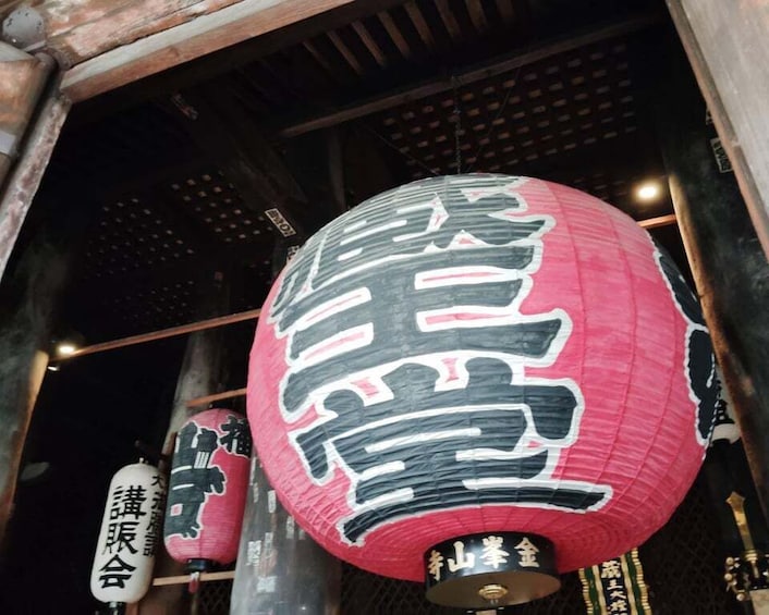 A red lantern with black and white calligraphy, hanging indoors. 5