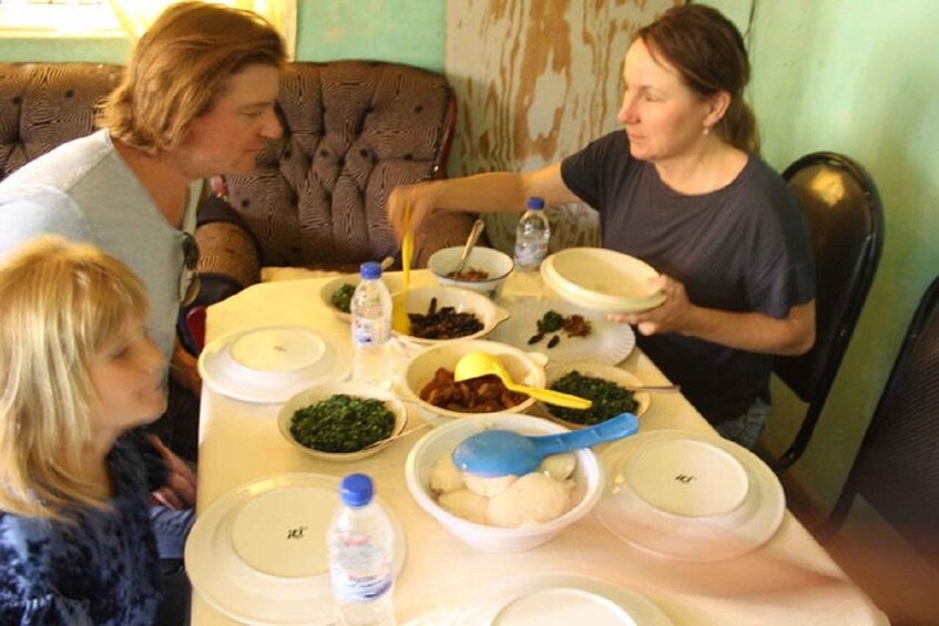 A family dining at a table with various dishes and drinks. 2
