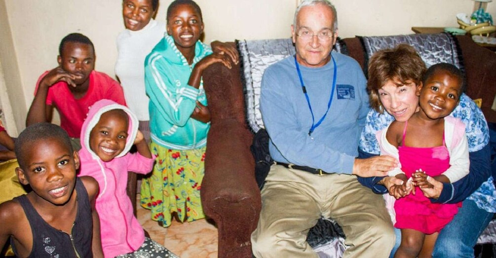 A group of people sitting on a couch in a living room. 5