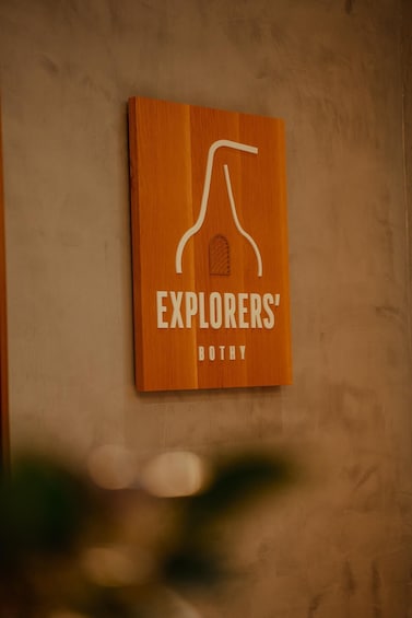 A wooden sign with the text 'EXPLORERS' BUTTY' on a textured wall. 3