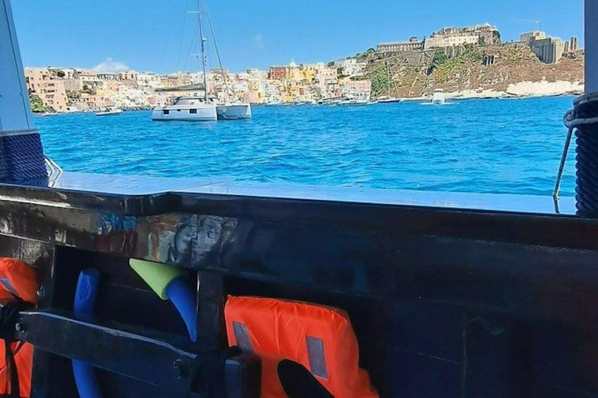 A boat with life jackets and a view of a coastal town with buildings and boats on the water. 5