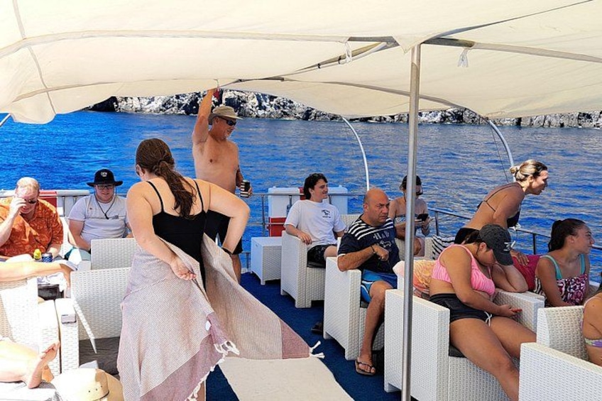 People on a boat with a rocky shoreline in the background. 5