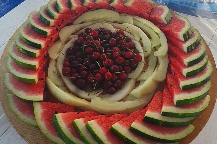 A watermelon and banana fruit salad with cherries in the center. 4