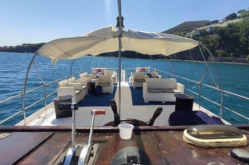 A boat deck with seating, a canopy, and a view of the water and land. 4
