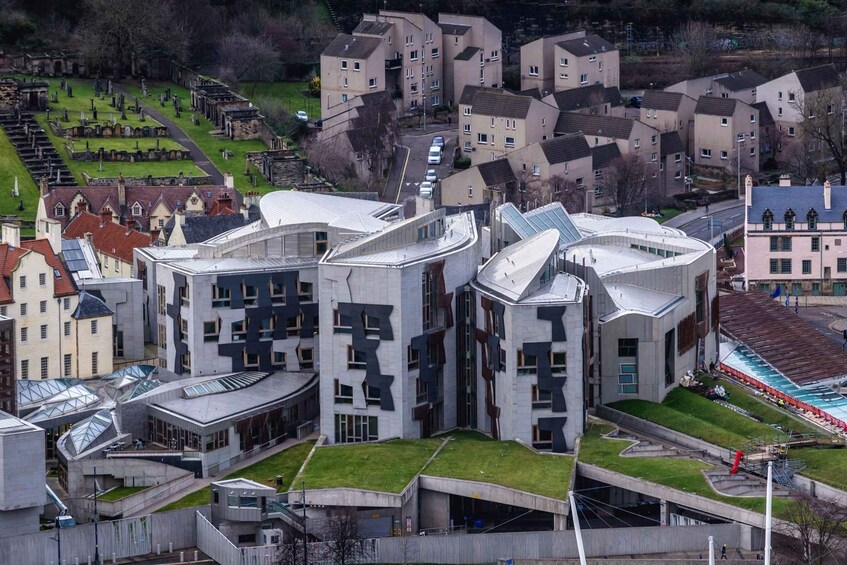A modern architectural complex with unique curved structures and a surrounding residential area. 3