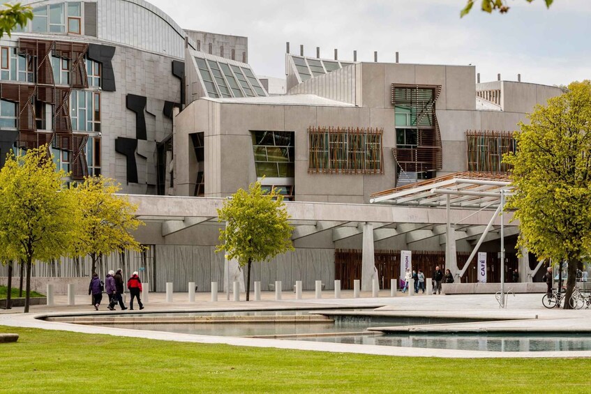 A modern building with unique architectural design, surrounded by a landscaped area with trees and a water feature. 4