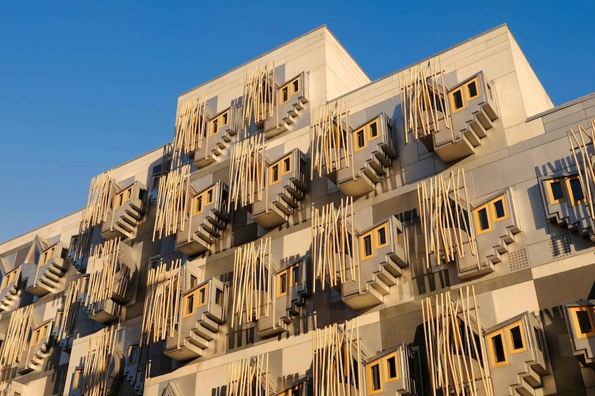 A modern building with a unique facade featuring numerous balconies and protruding staircases. 5
