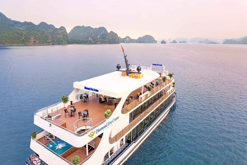A cruise ship with multiple decks, outdoor seating, and a swimming pool. 1
