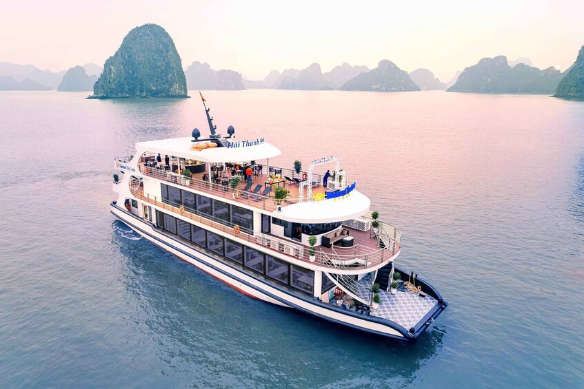 A large river cruise ship with a covered upper deck and a lower deck with seating. 4