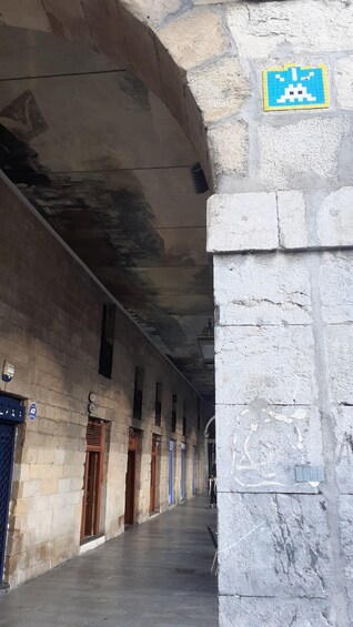 A corridor with stone walls, wooden doors, and a blue sign. 2