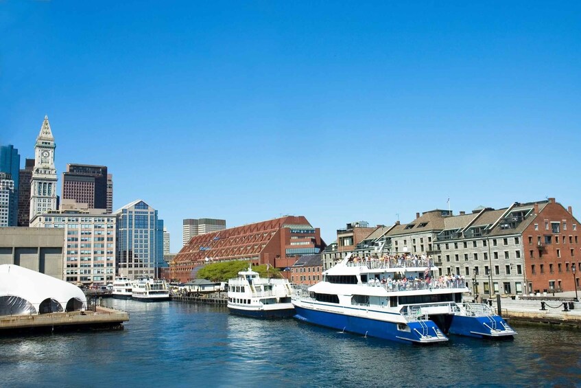 A harbor with boats, a clock tower, and modern buildings. 1