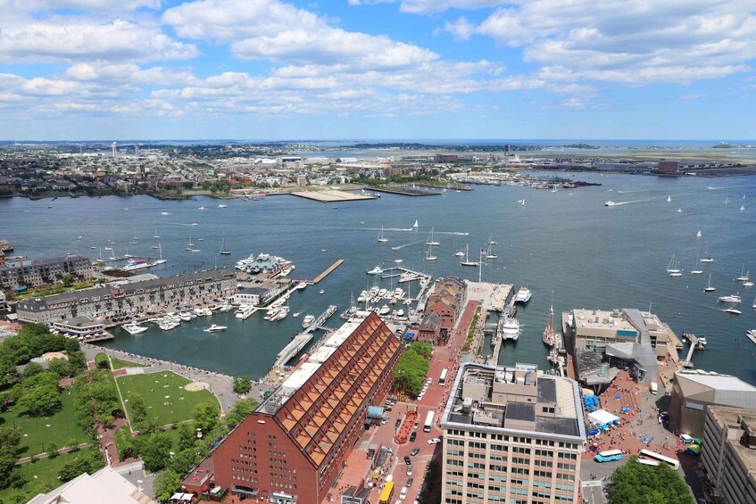 A harbor with boats, a large red building, and a cityscape in the background. 2