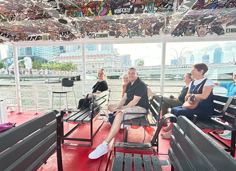 A group of people seated on benches with a cityscape view through large windows. 3
