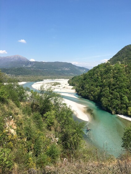 A river winding through a forested valley with mountains in the background. 1