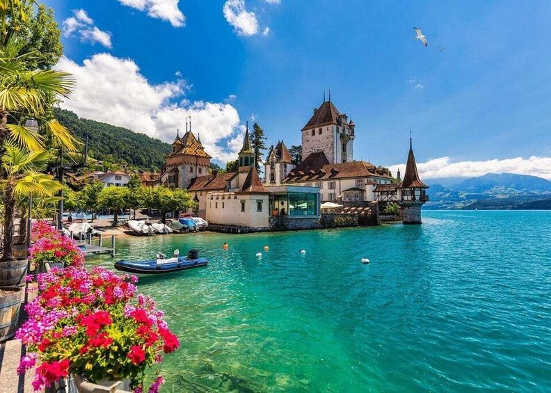 A lakeside town with historic buildings, clear water, and boats. 2