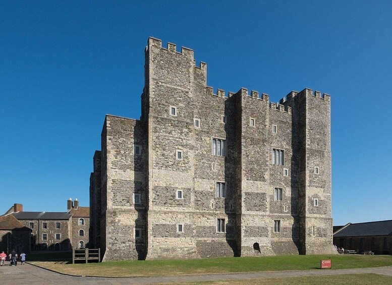 A large stone castle with multiple towers and a grassy courtyard. 1