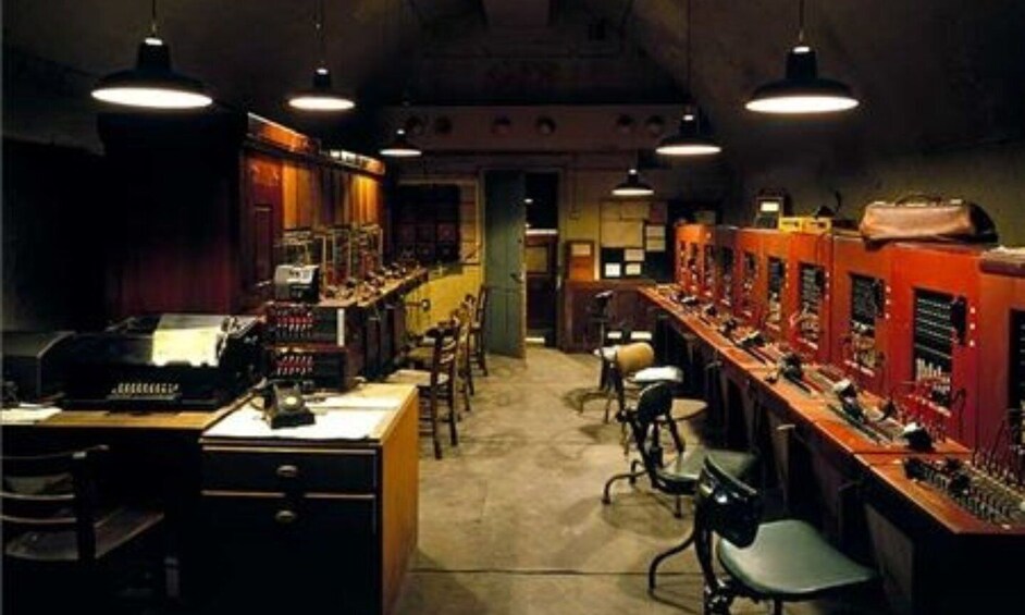 A dimly lit room with vintage equipment, wooden cabinets, and hanging lights. 2