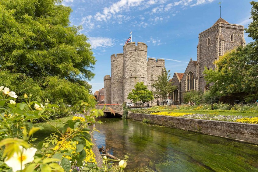 A historic castle with a tower, a river, and a bridge. 3