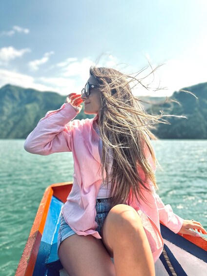 A person sitting on a boat with a mountainous landscape in the background. 5