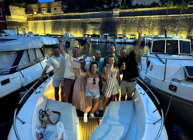 A group of people on a boat with a historic stone wall and boats in the background. 5