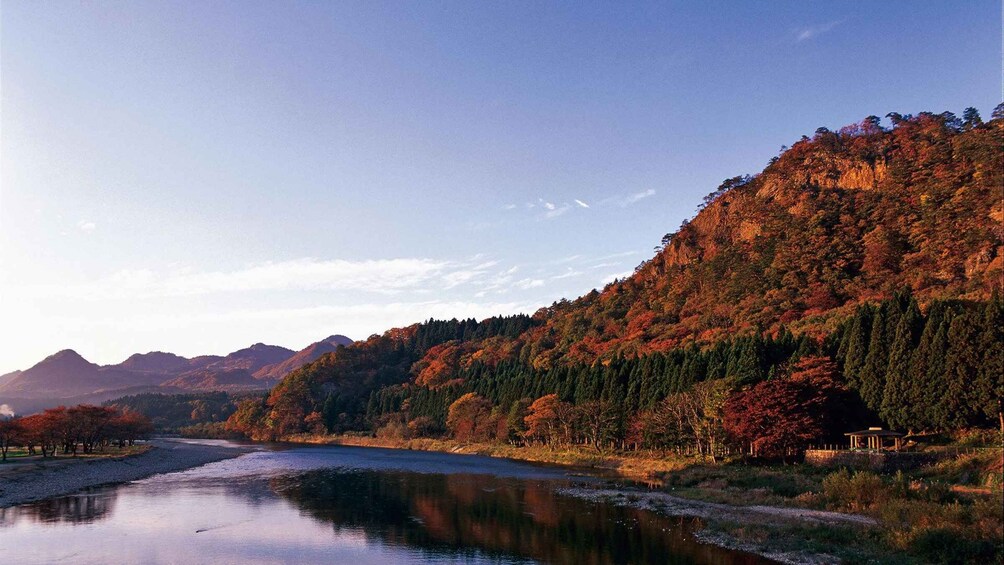 A river flowing through a mountainous landscape with autumn foliage. 3