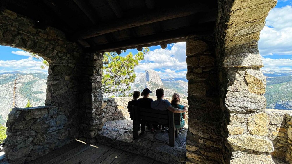 A stone structure with a wooden bench overlooking a mountainous landscape. 3