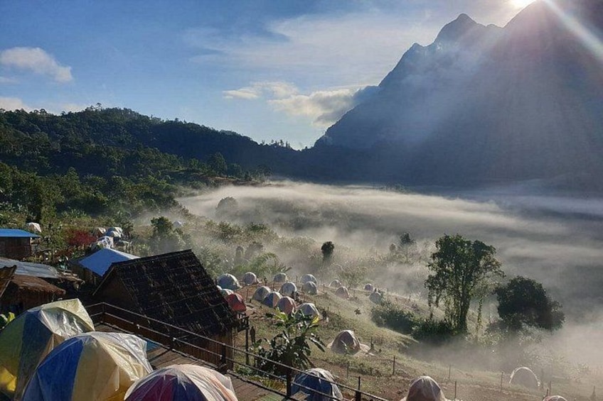 A mountainous landscape with a valley, houses, and sheep. 2