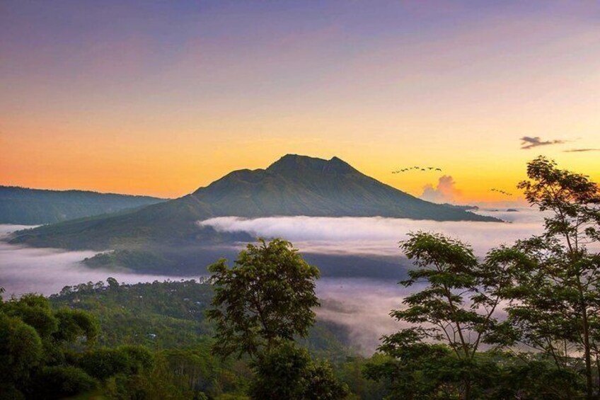 A mountain at sunrise with clouds below. 3