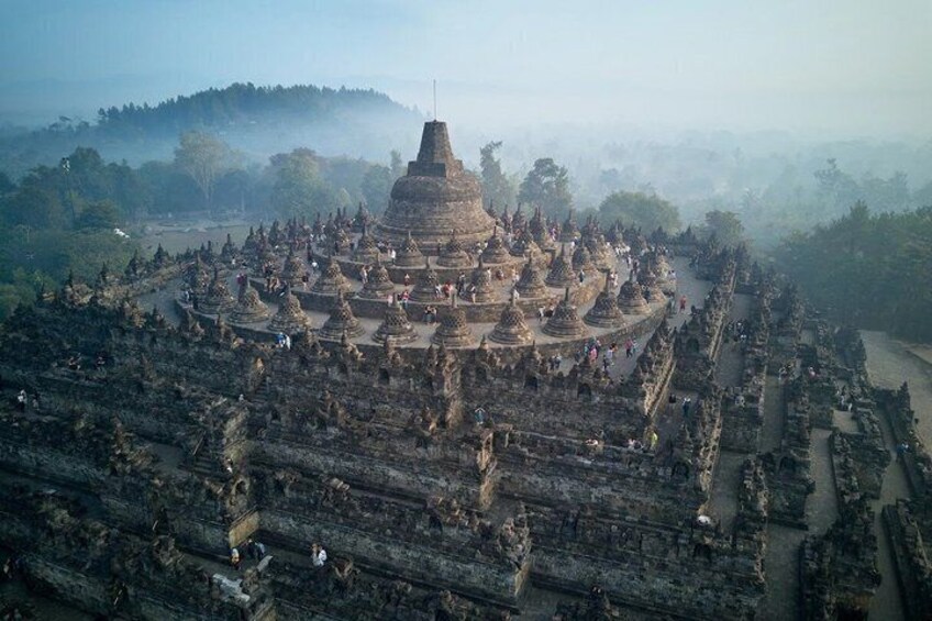 An ancient temple complex with multiple structures, including a central stupa surrounded by smaller buildings. 2