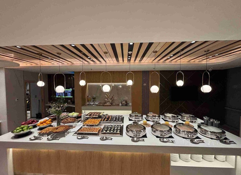A buffet with various food items and plates. 5