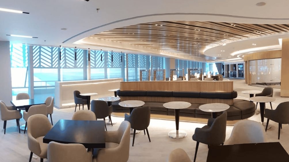 A modern lounge area with a reception desk, seating, and tables. 1