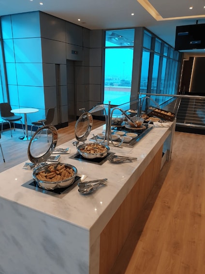A buffet setup with various food items and serving utensils. 3
