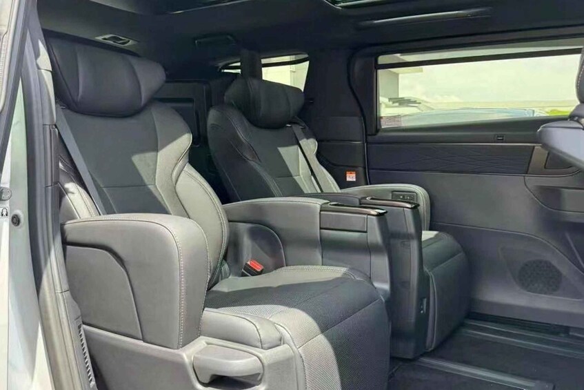 A car's interior with grey leather seats, a center console, and a sunroof. 5