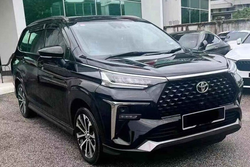 A black Toyota SUV parked in front of a building with glass windows. 4