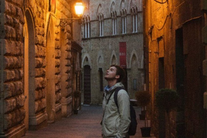 Une ruelle étroite aux murs de pierre, avec une personne debout au milieu. 2