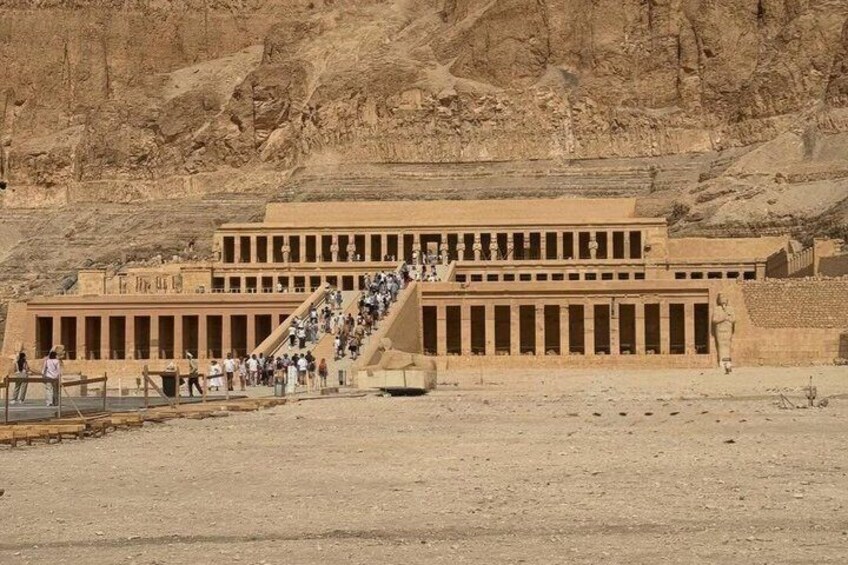 Un grande tempio egizio antico con una lunga scalinata che conduce all'ingresso. 5