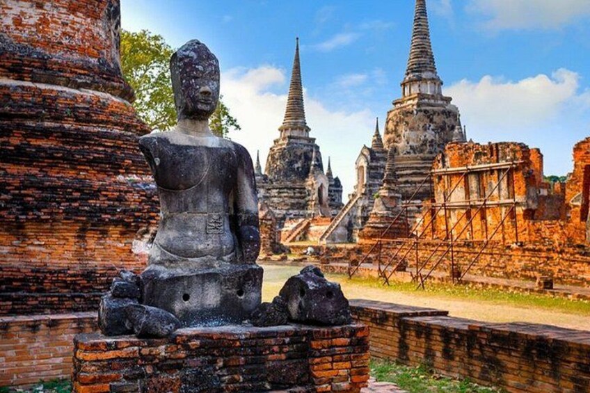 A stone Buddha statue, ancient brick structures, and temple spires. 2
