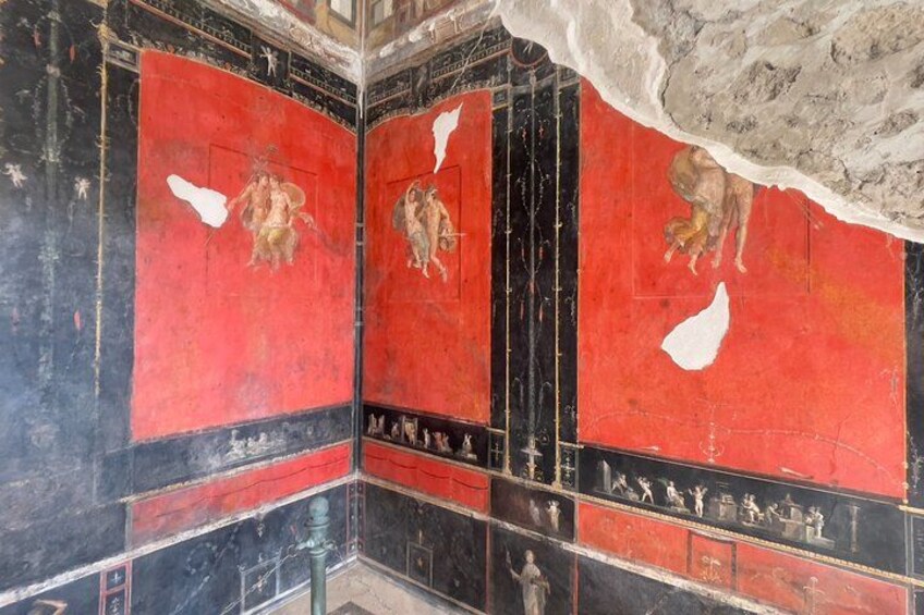 Parte de un edificio con mosaicos rojos y negros, algunos dañados o faltantes. 4